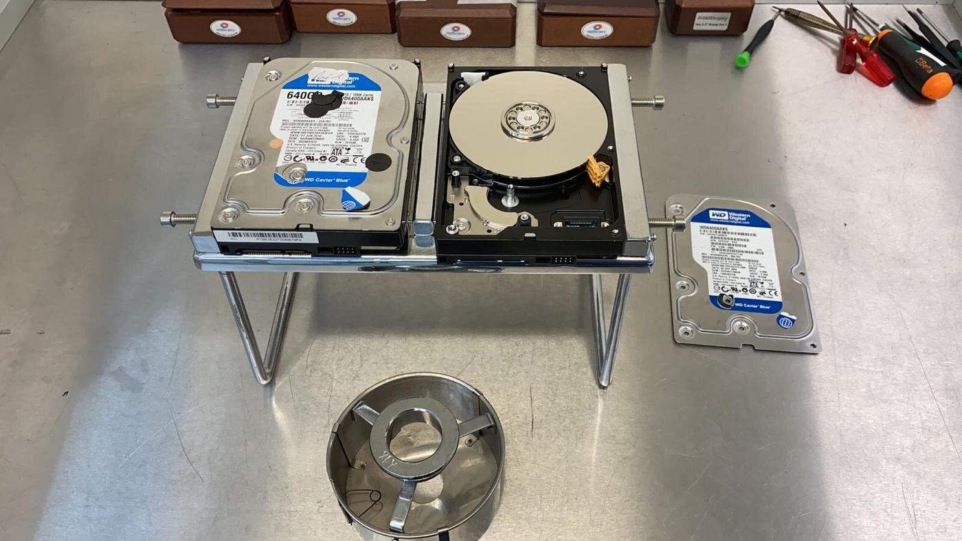 Hard drives opened on a stand for data recovery